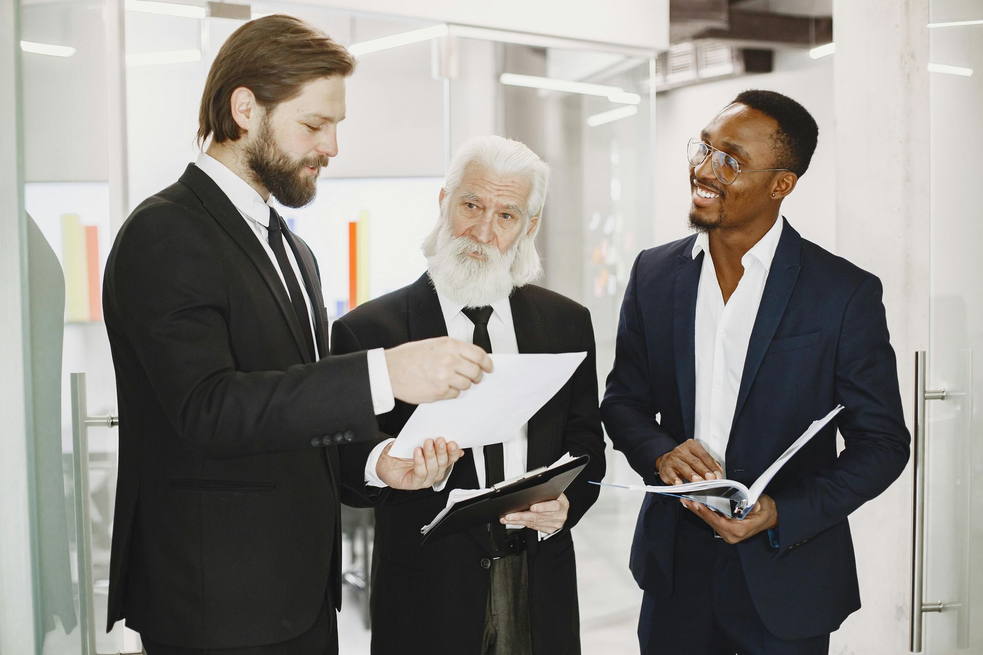 A group of businessmen are standing next to each other in an office.