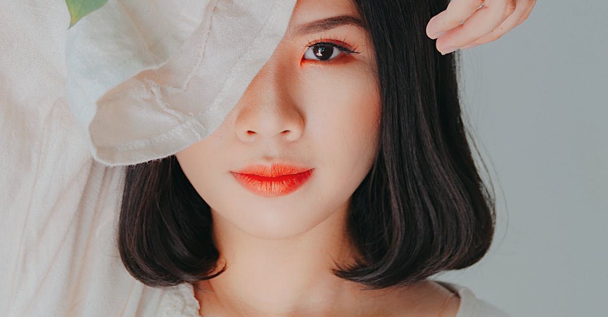 A woman is covering her face with a white cloth.