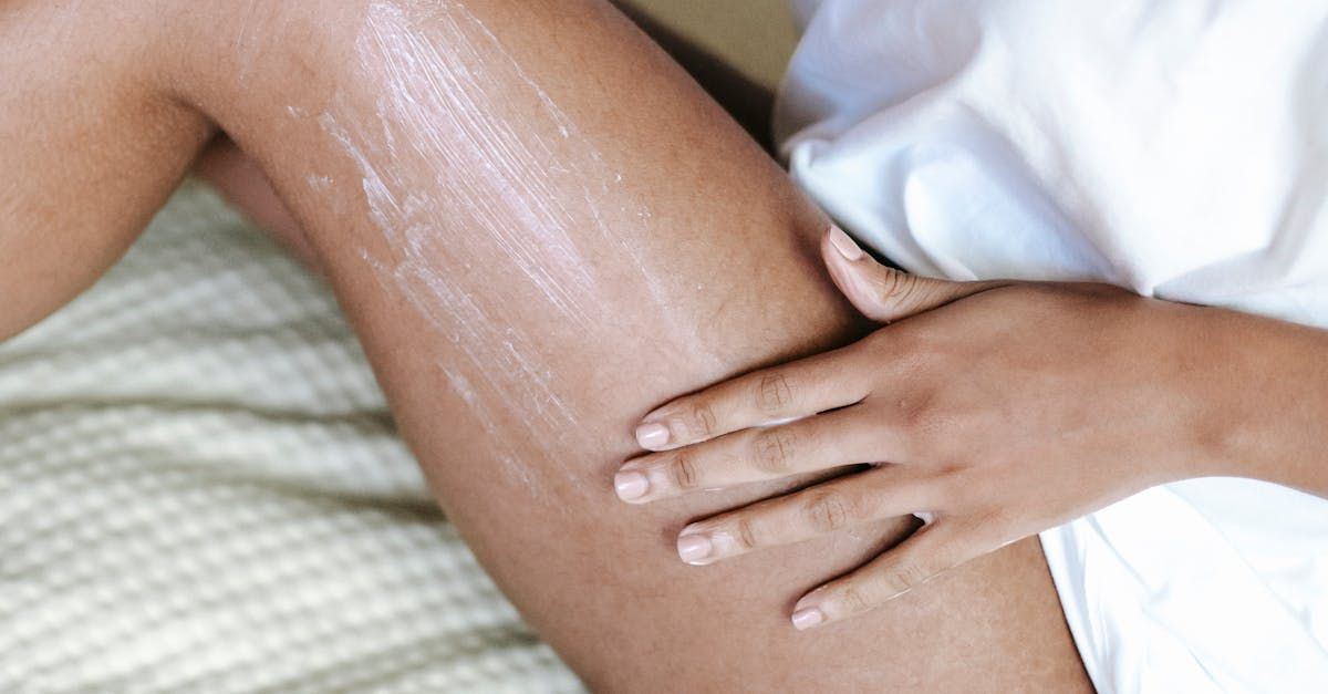 A woman is applying lotion to her leg.