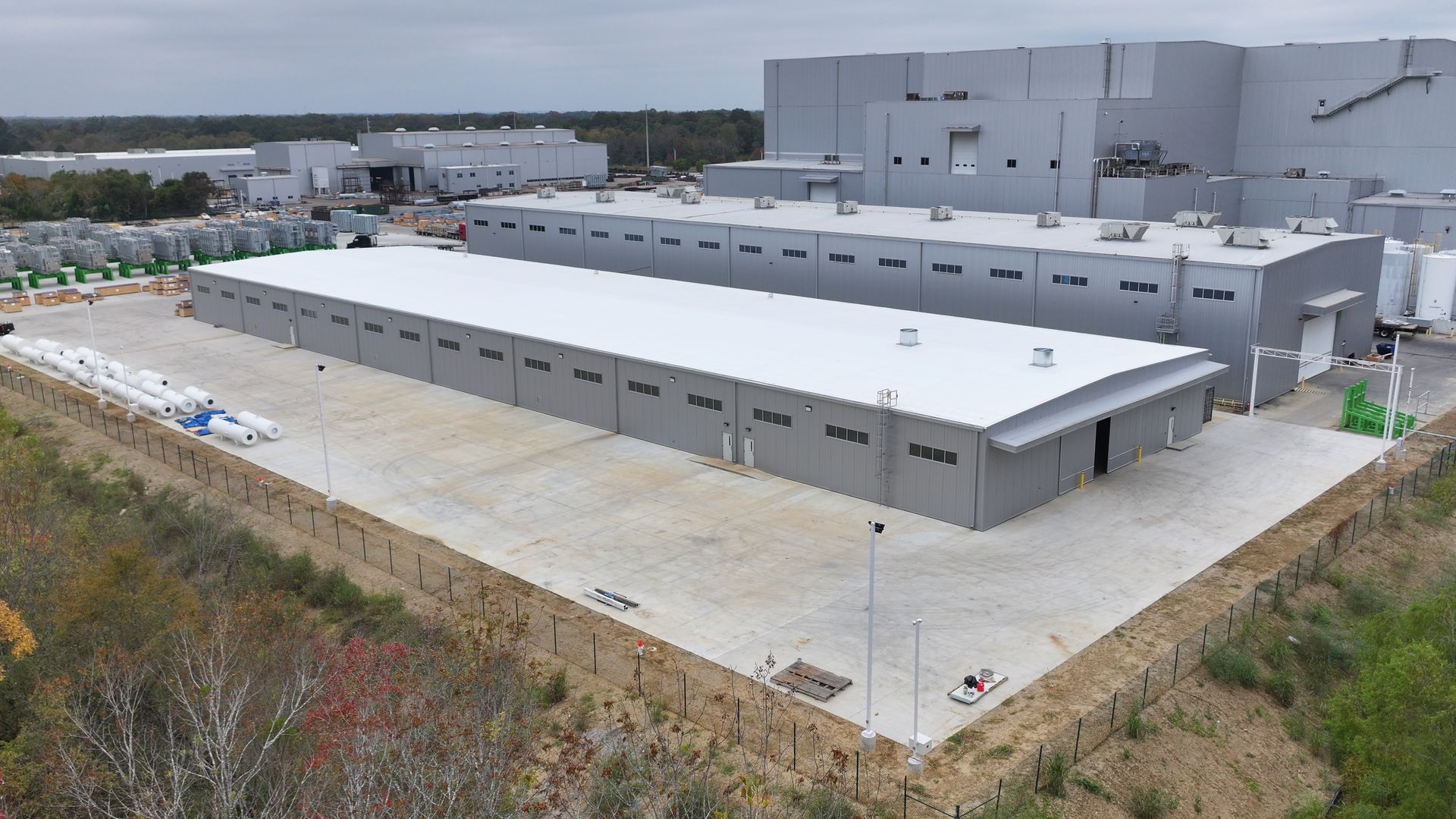 An aerial view of a large warehouse with a white roof.