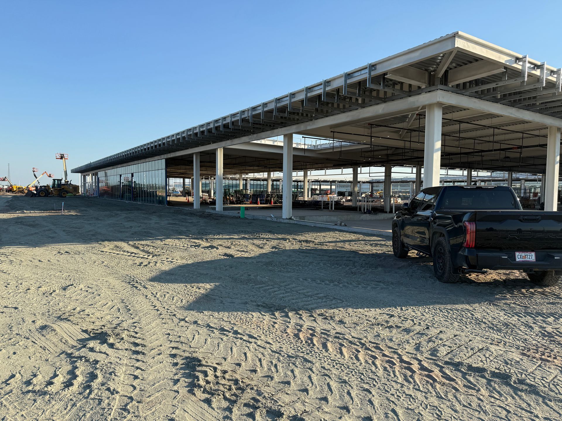 A black truck is parked in front of a building under construction