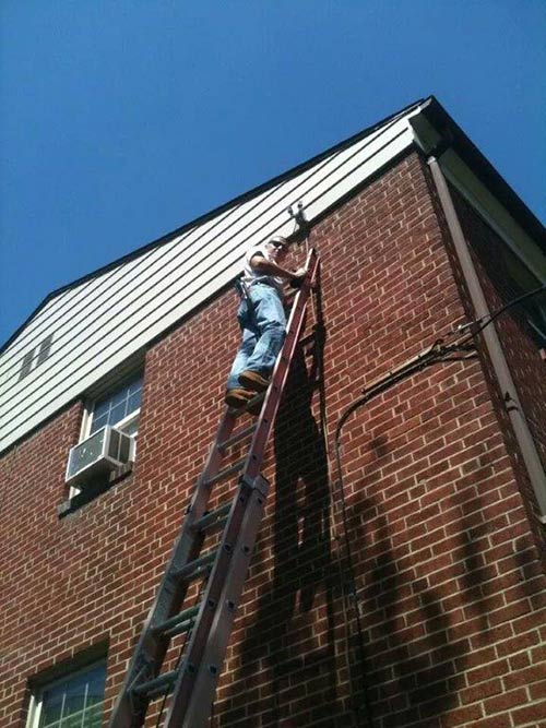 Man Climbing on a Ladder — Quality Electric Service in Annandale, VA
