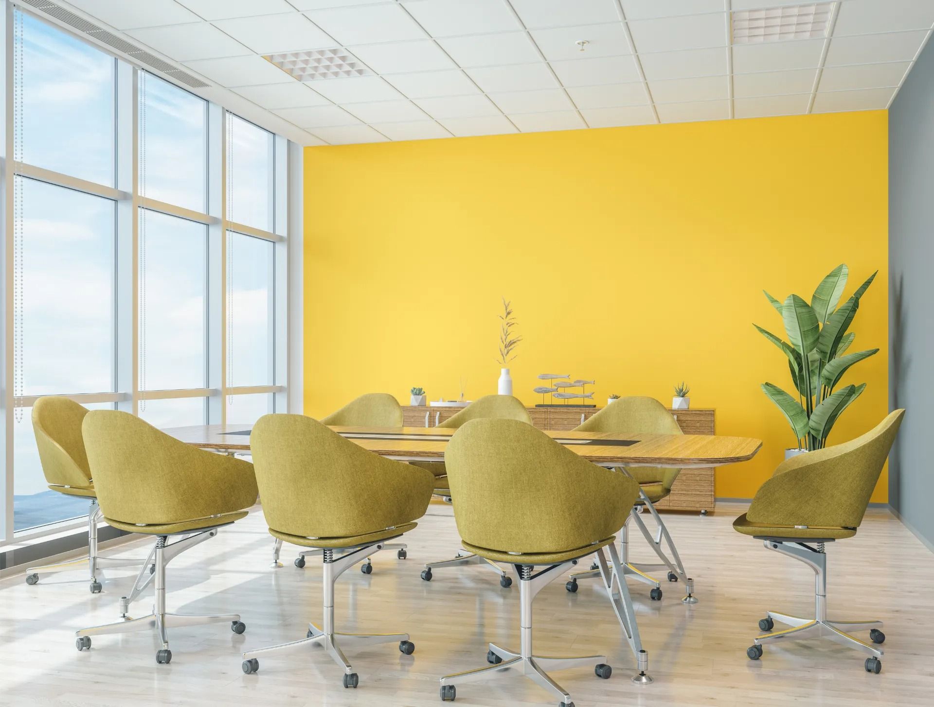 A conference room with a table and chairs and yellow walls.