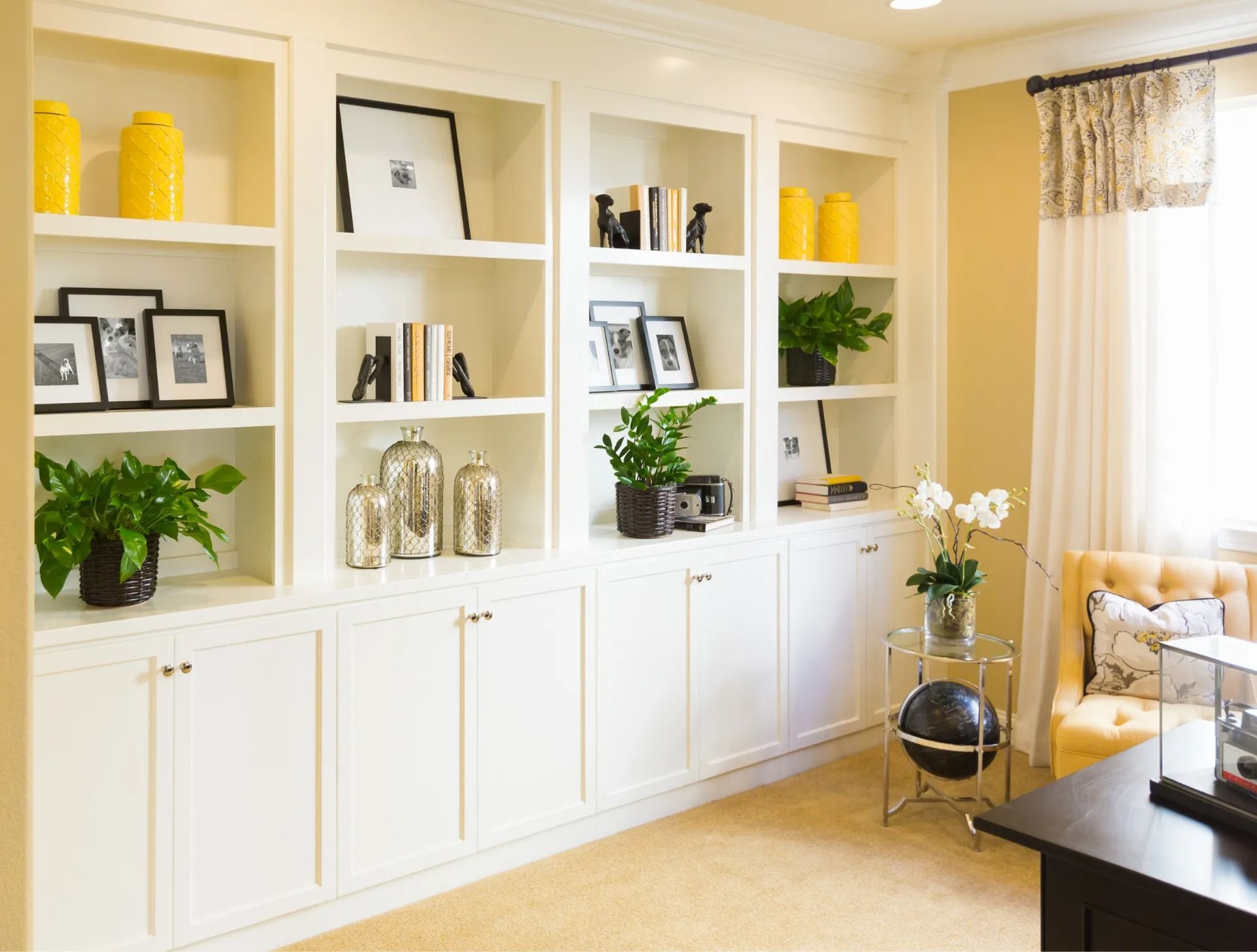 A living room with a lot of shelves and a desk.