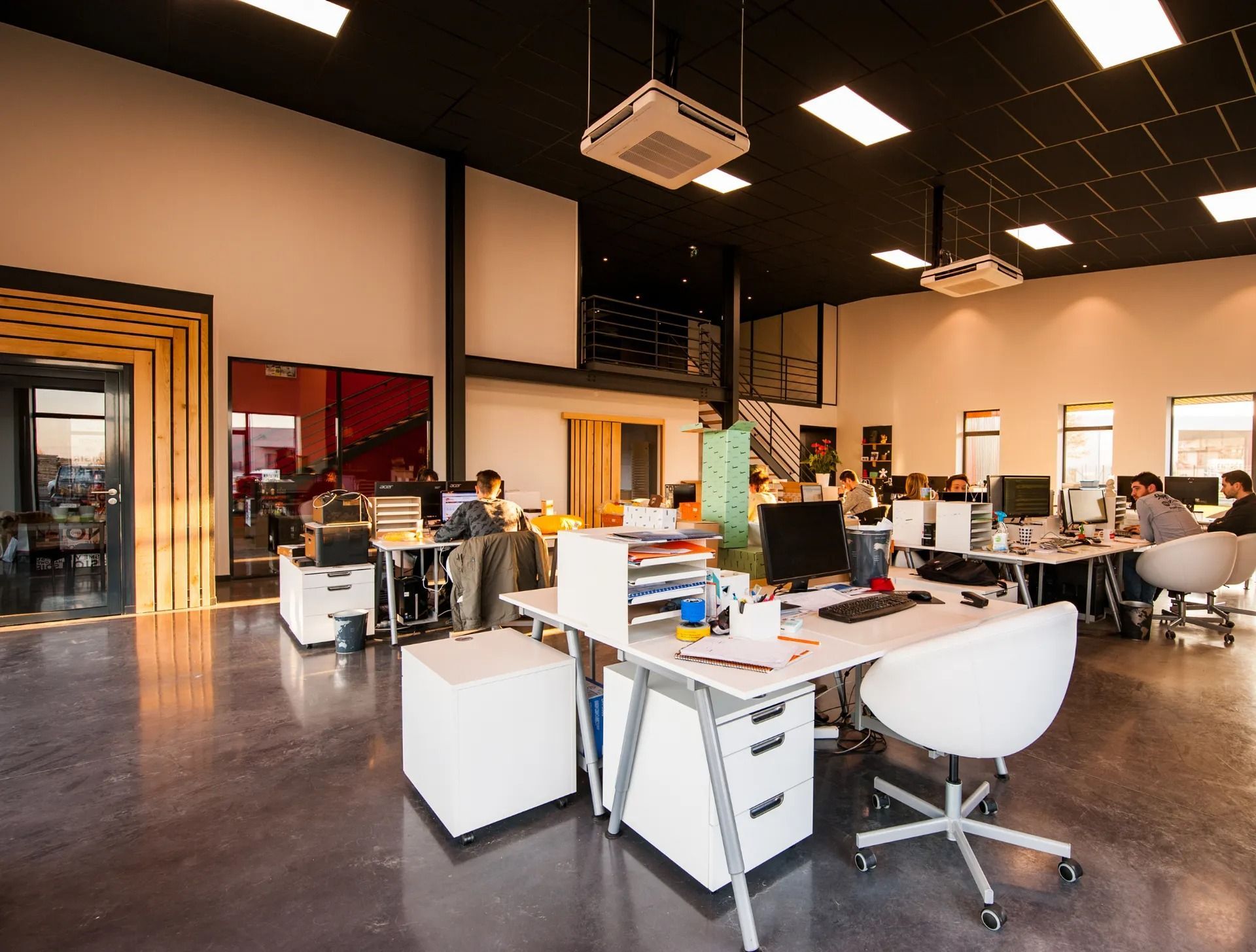 A group of people are sitting at desks in an office.