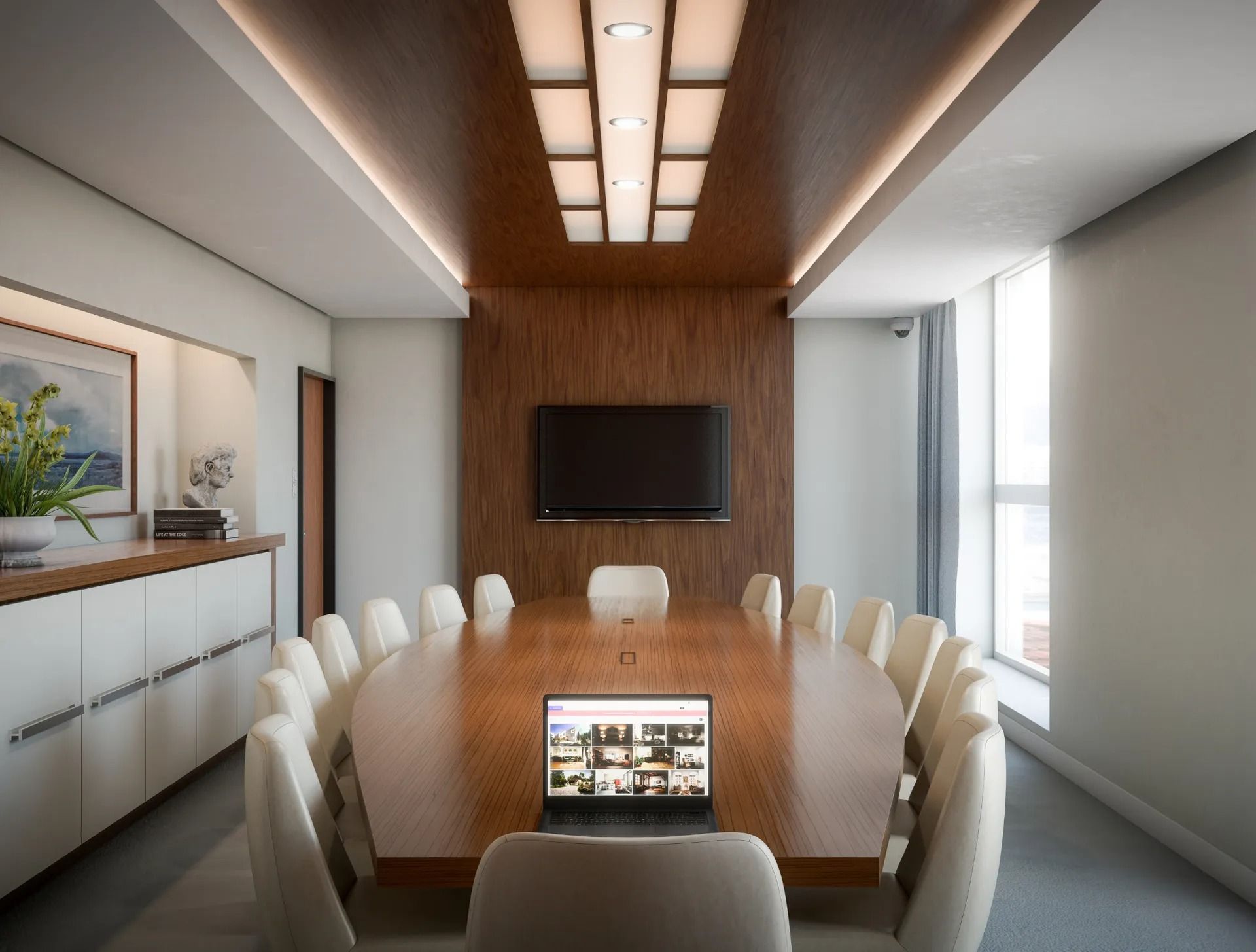 A conference room with a long table and chairs and a laptop on the table