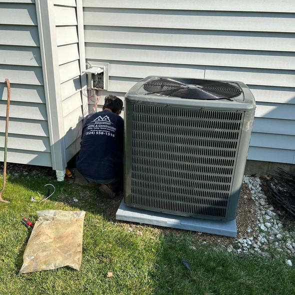 A man is working on an air conditioner outside of a house