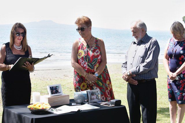 A group of people are standing around a table on a beach.
