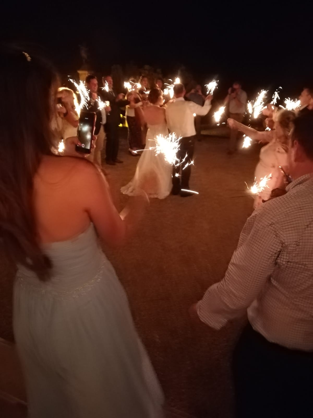A bride and groom are dancing with sparklers at their wedding reception