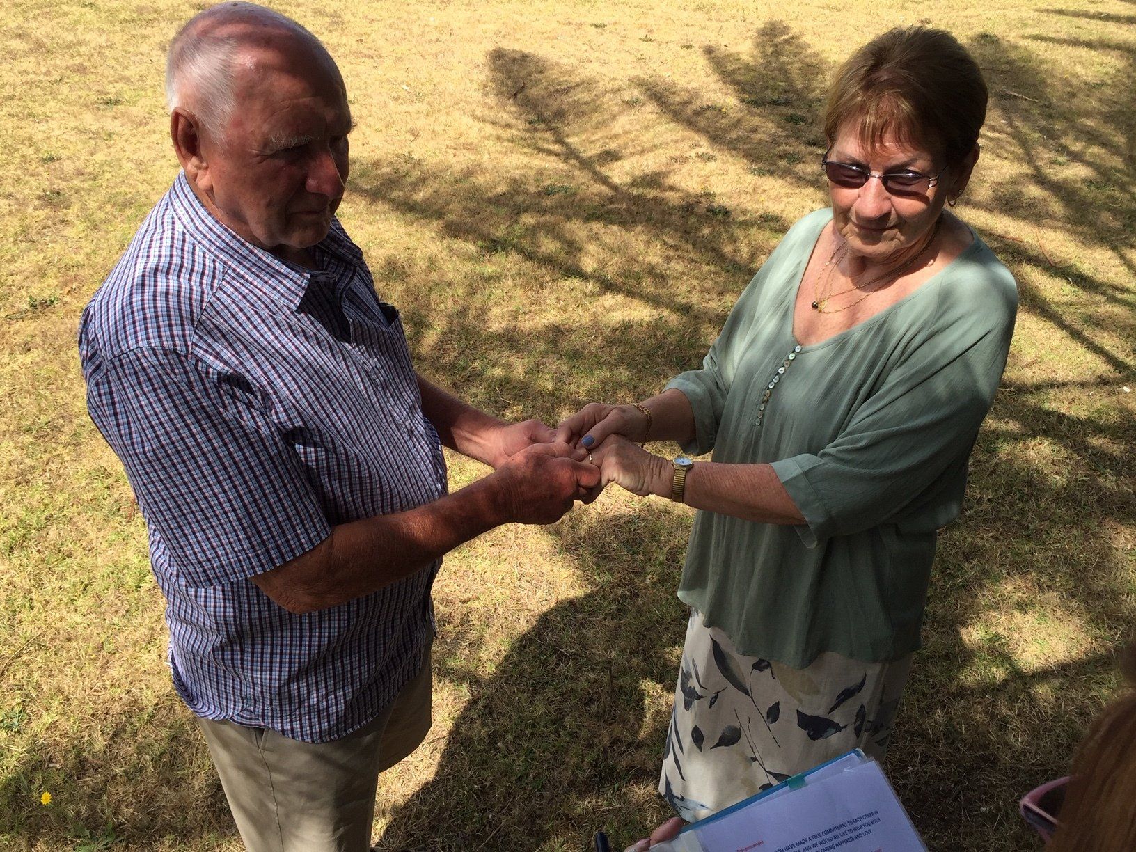 A man and a woman are holding hands in a field.