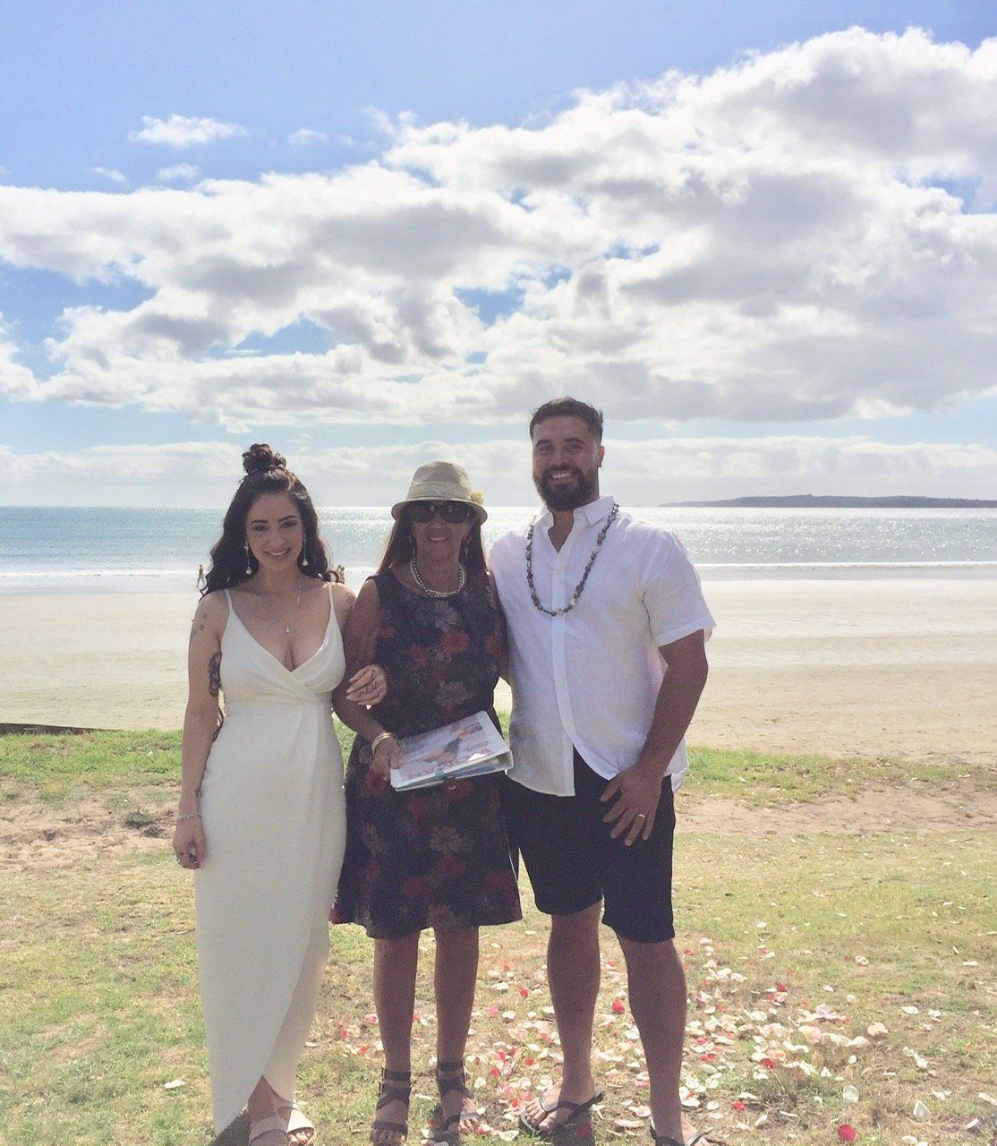 A group of people standing next to each other on a beach.