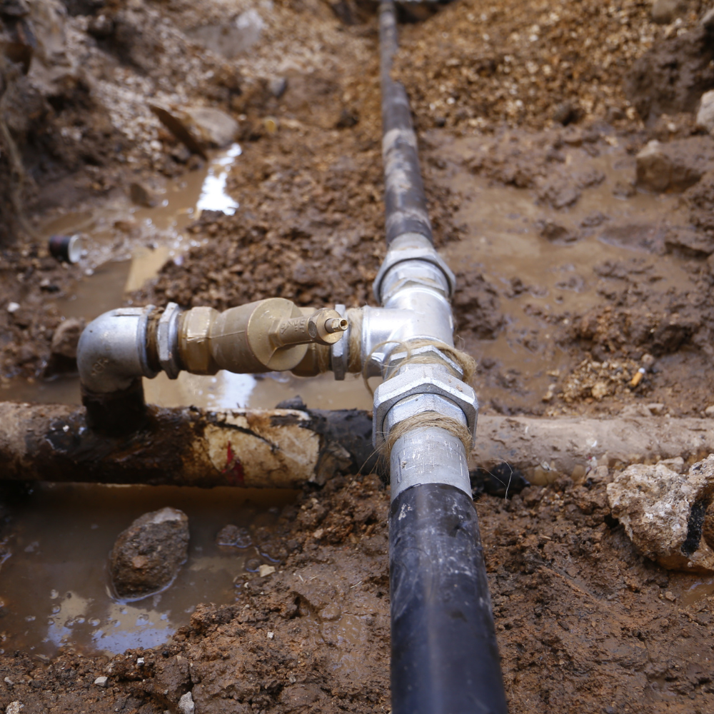 A close up of a water pipe in the dirt