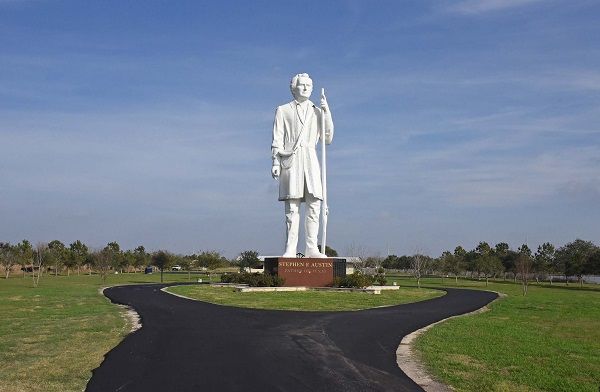 A large white statue of Abraham Lincoln stands in a grassy area, with roads leading to it.