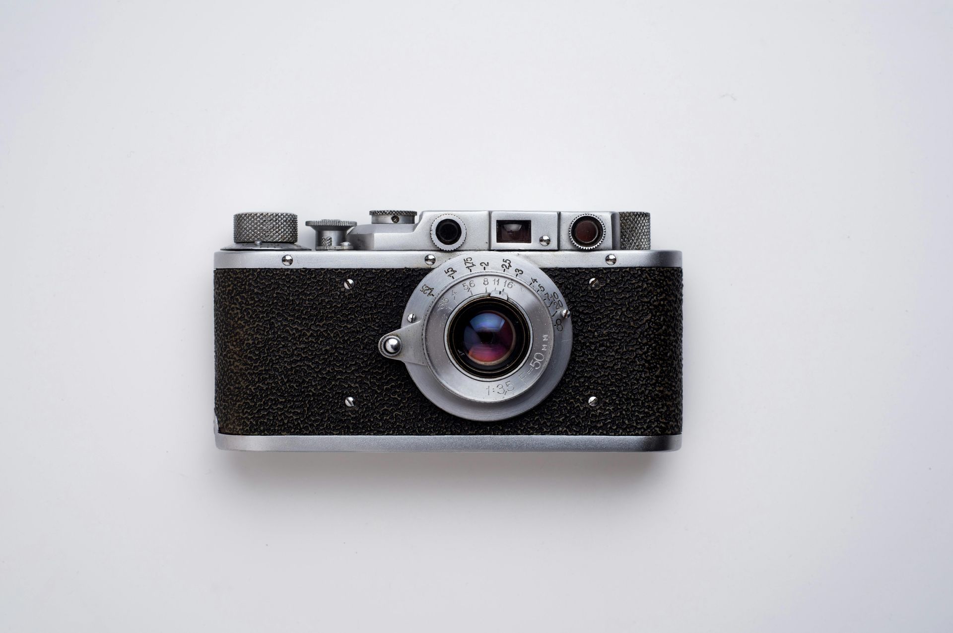 Vintage black and silver camera, centered on a white background.