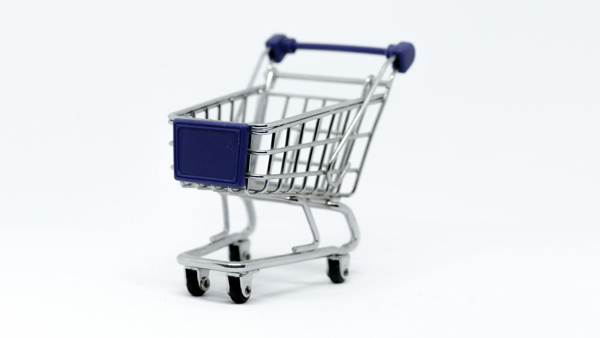 Miniature shopping cart with a blue front and handle, sitting on a white surface.