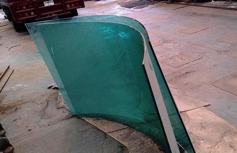 Un gran trozo de vidrio se encuentra en el suelo frente a un camión rojo.