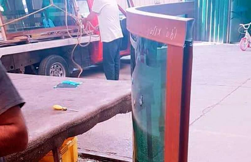 Un hombre está parado junto a un gran acuario en un estacionamiento.