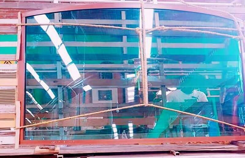 Una gran ventana se encuentra encima de una mesa de madera.