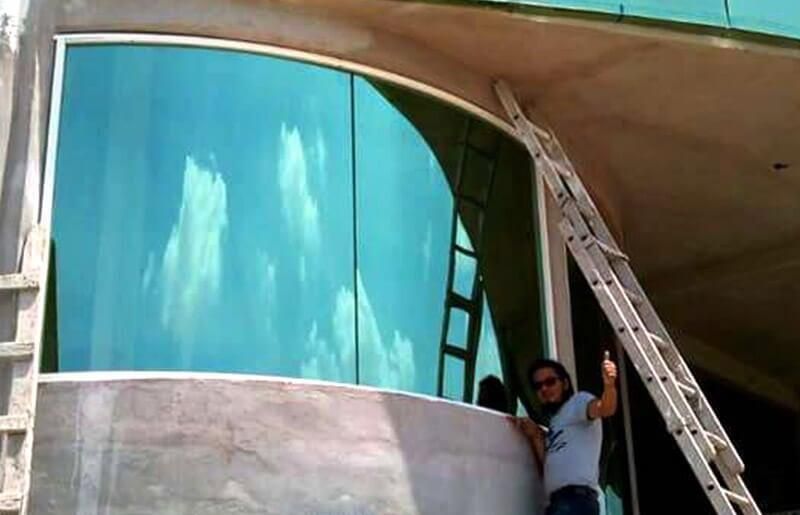 Un hombre parado en un balcón con una escalera haciendo un gesto de aprobación con el pulgar hacia arriba.