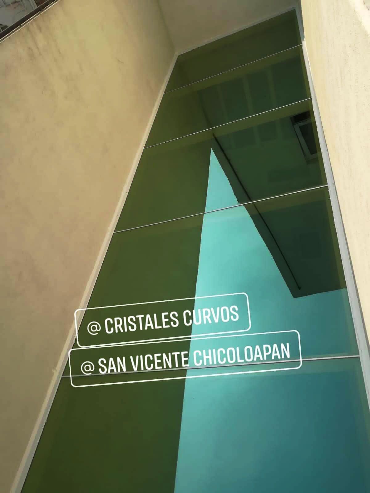 Una pared verde y azul con un cartel que dice cristales curvos