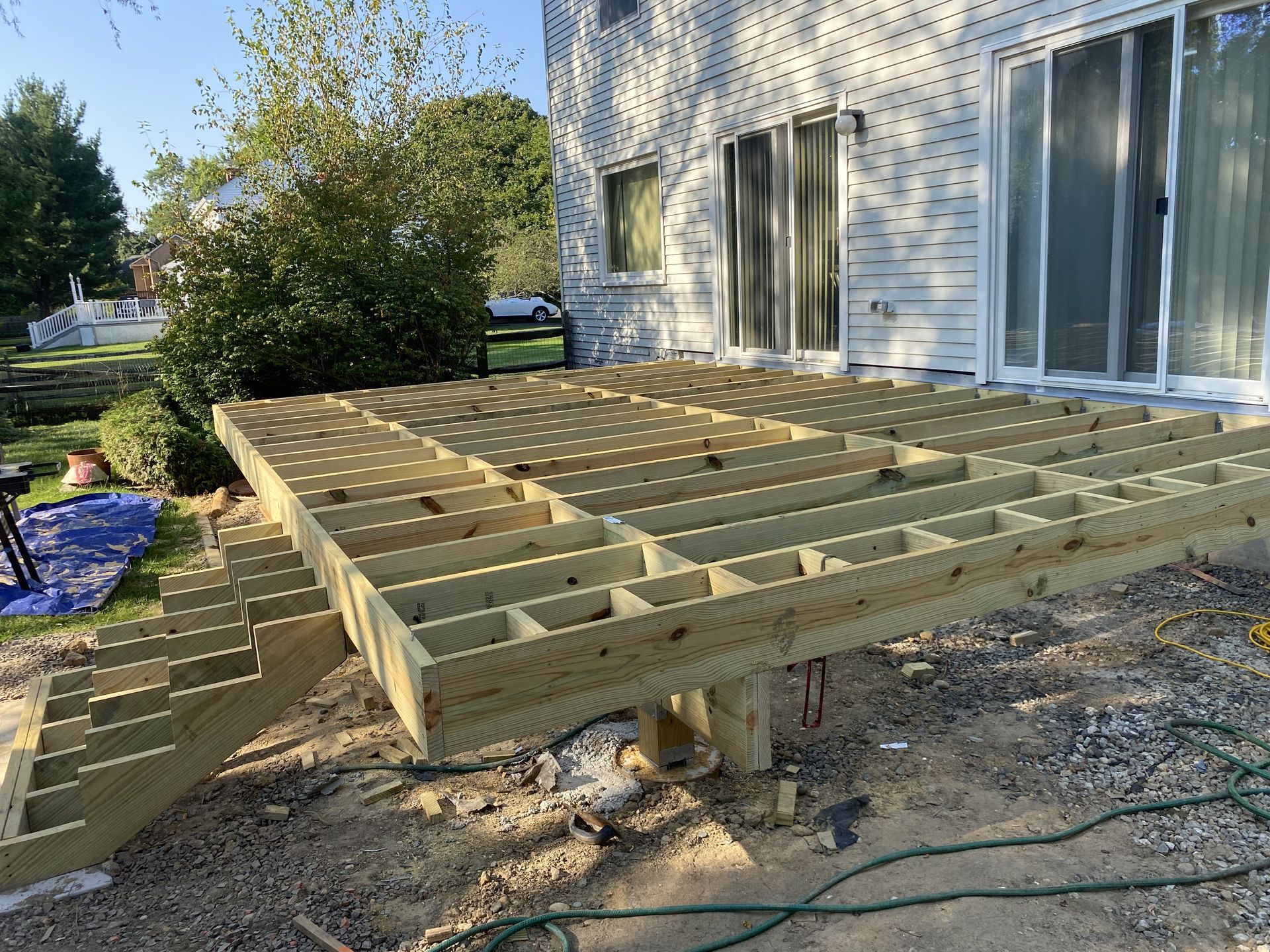 A wooden deck is being built in front of a house.