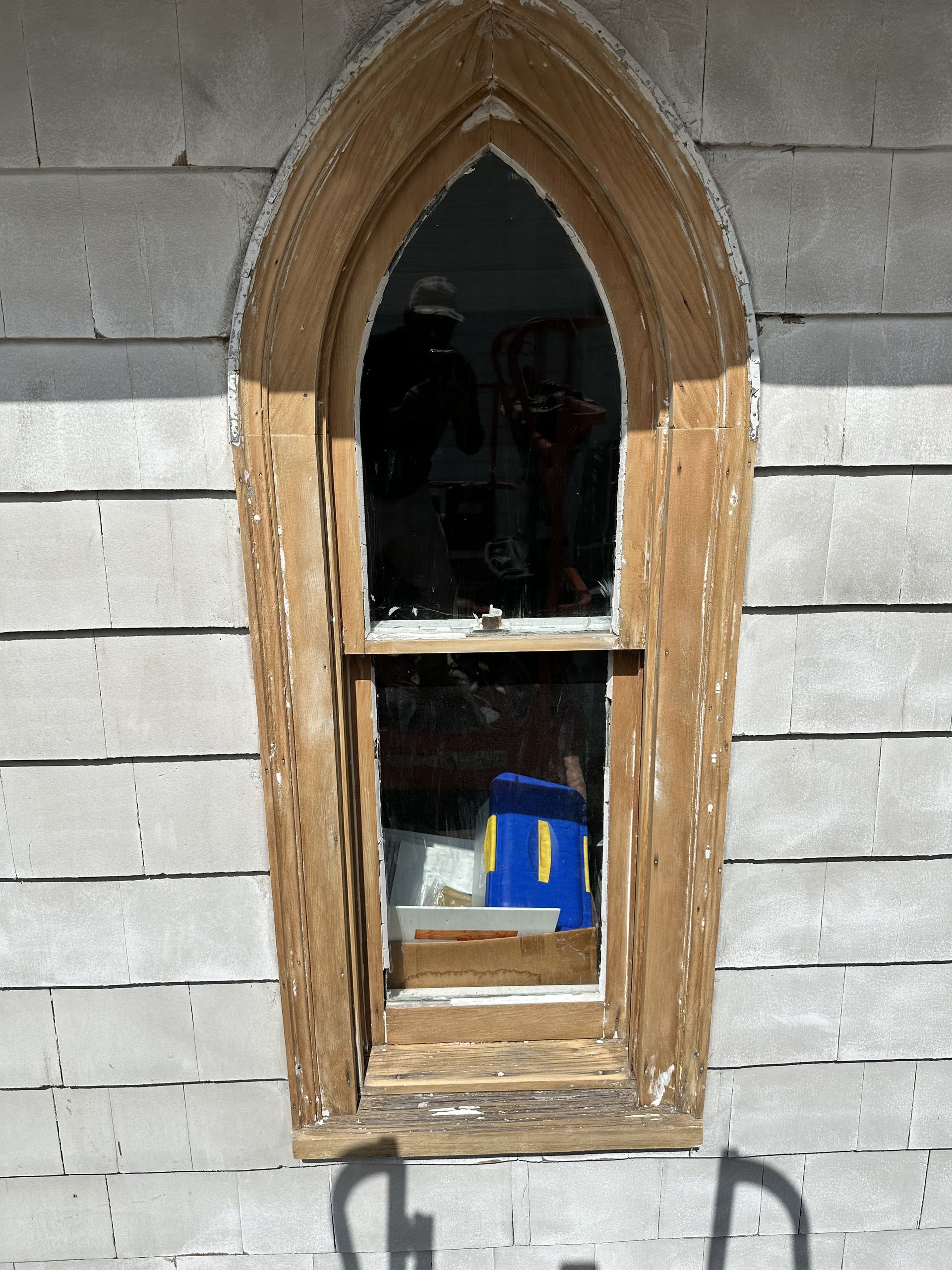 A window with a wooden frame on a white wall