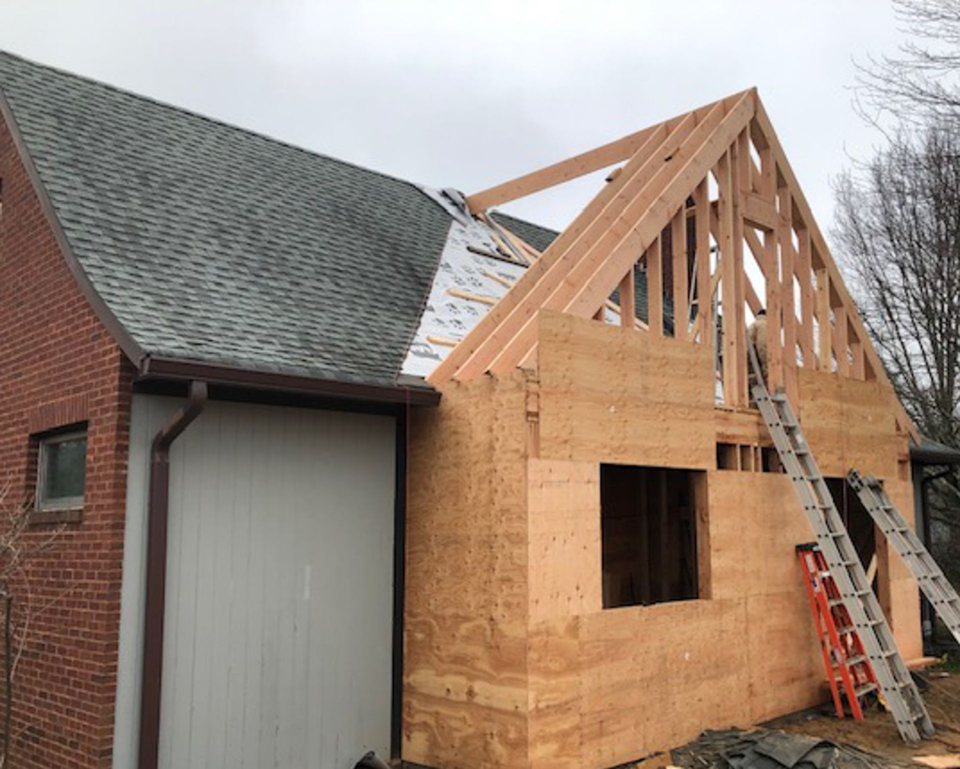 A ladder is sitting on the side of a house under construction.