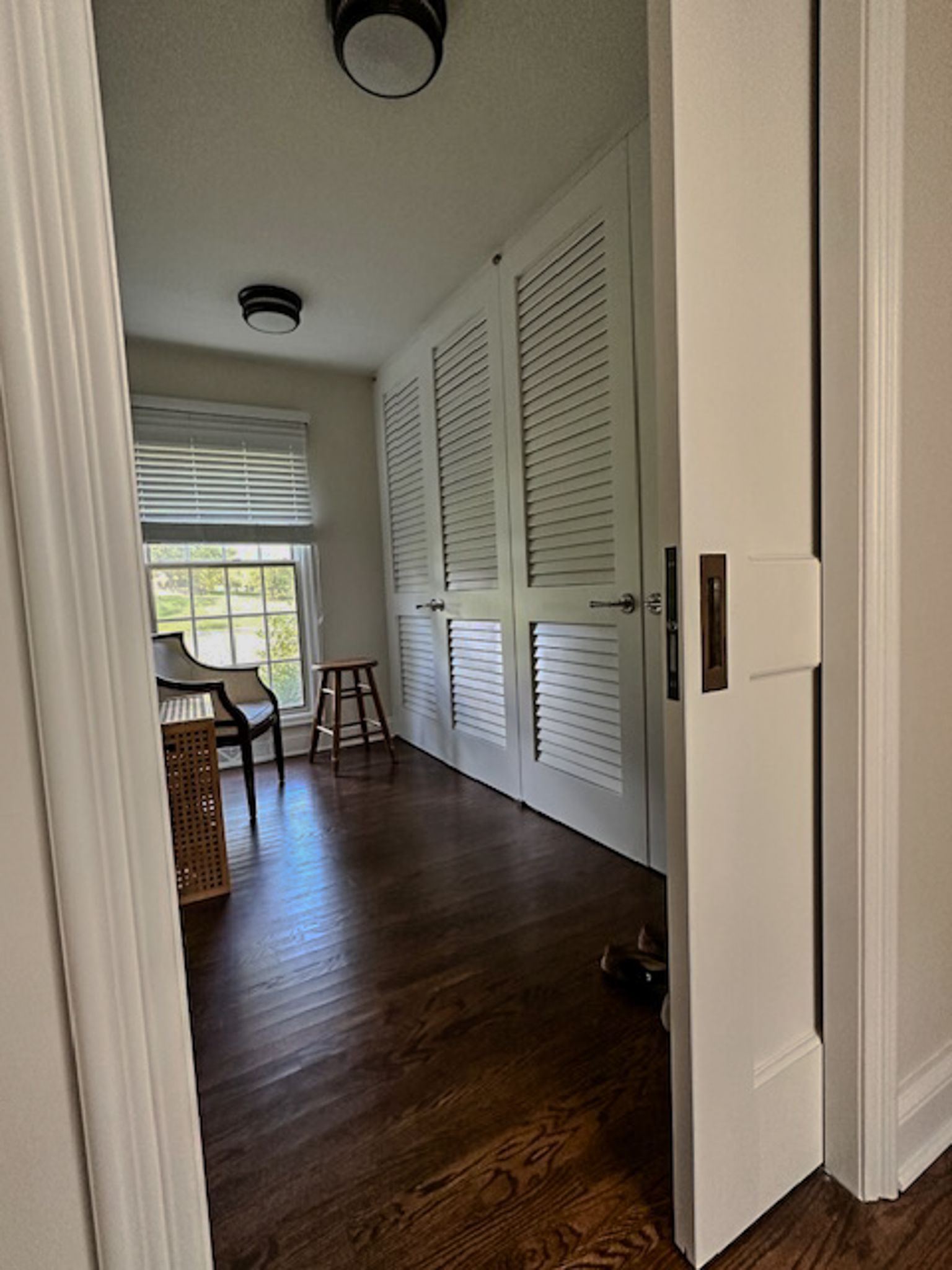 A room with hardwood floors and white shuttered doors