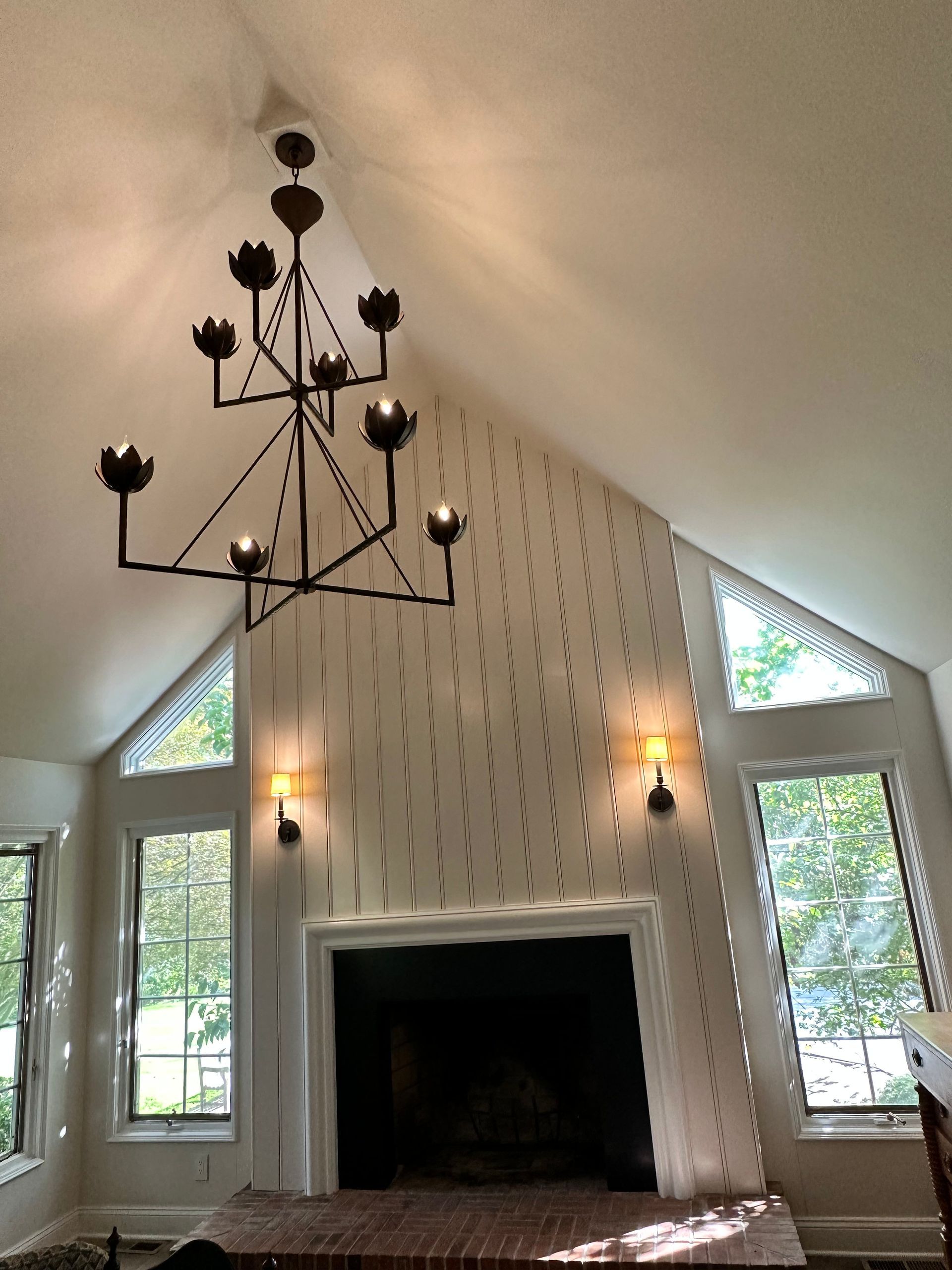 A living room with a fireplace and a chandelier hanging from the ceiling