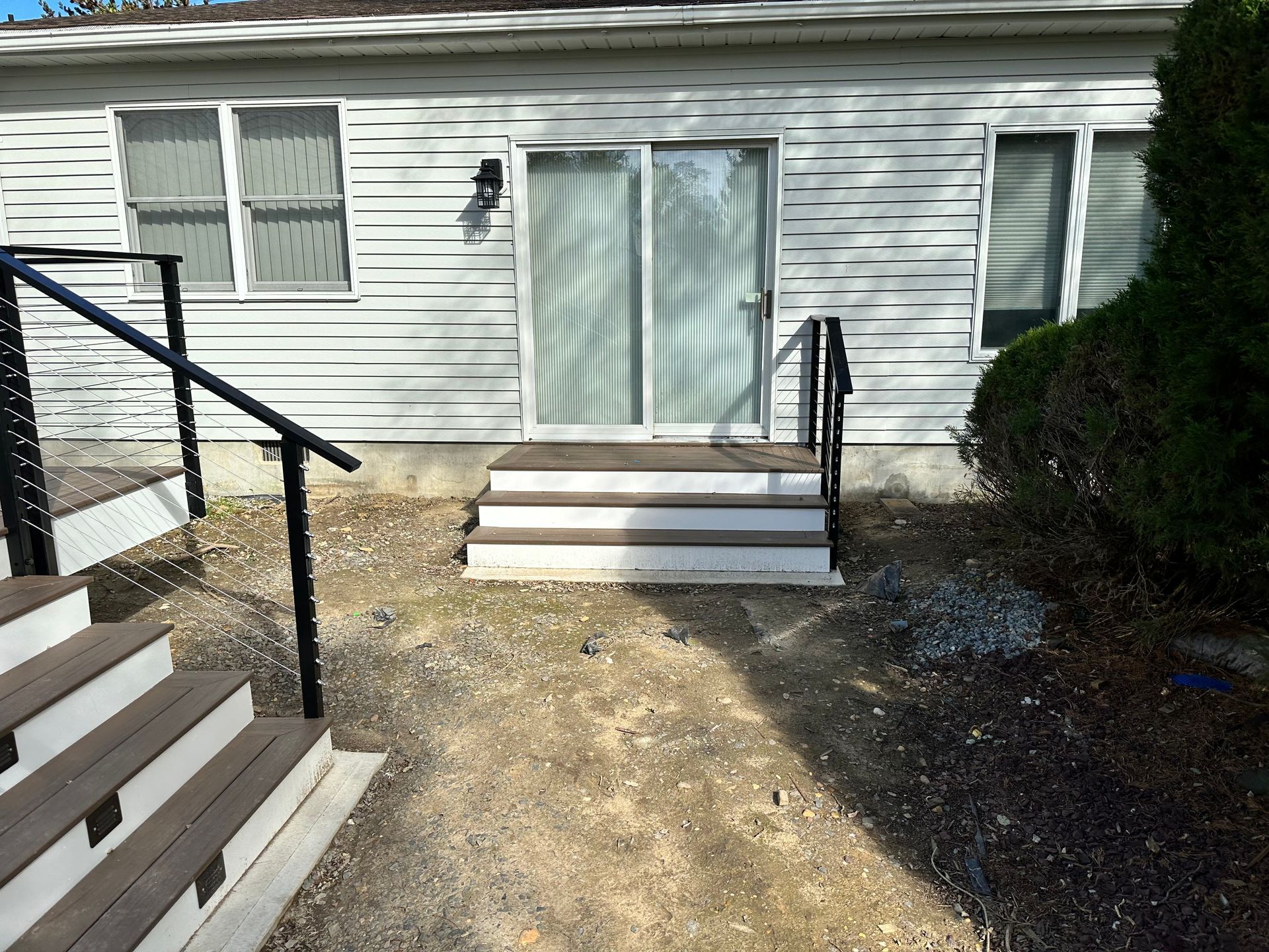 A white house with stairs and a sliding glass door