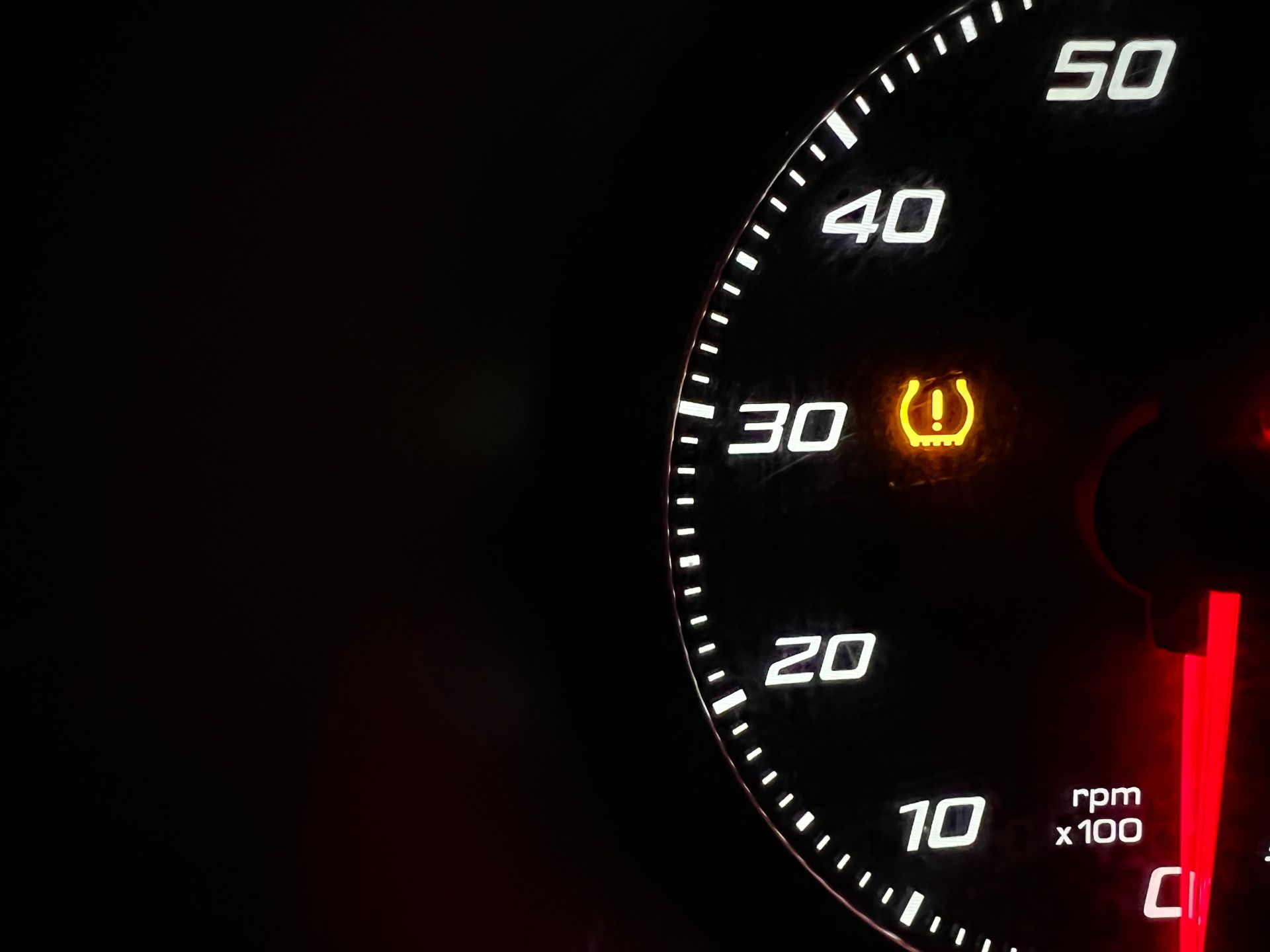 Dashboard with speedometer and illuminated tire pressure warning light.