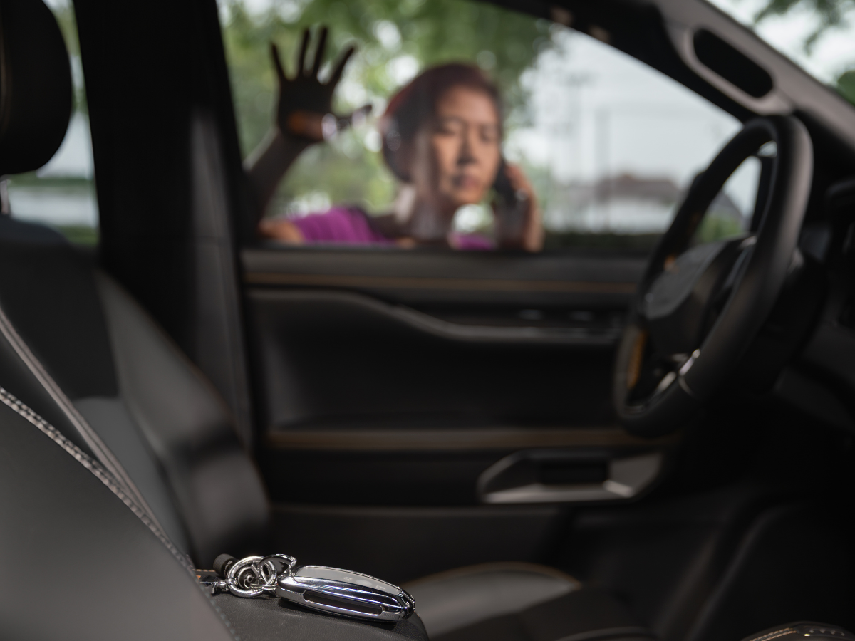 A woman is sitting in a car talking on a cell phone