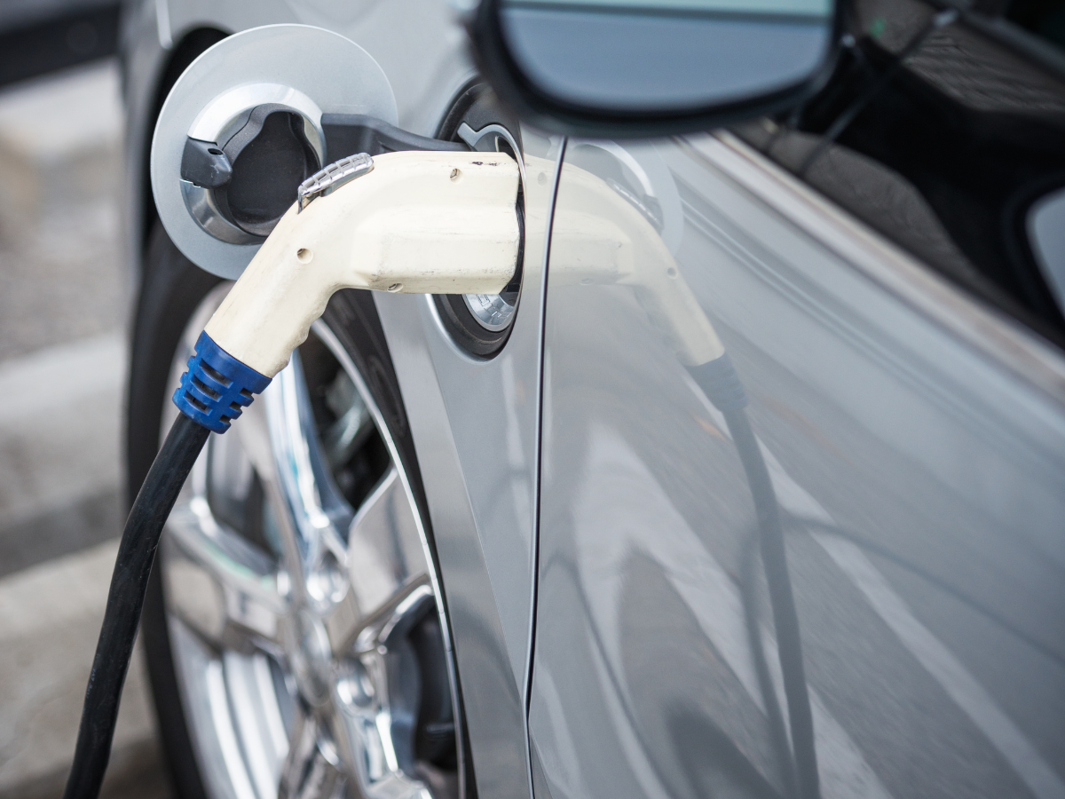 An electric car is being charged at a charging station.