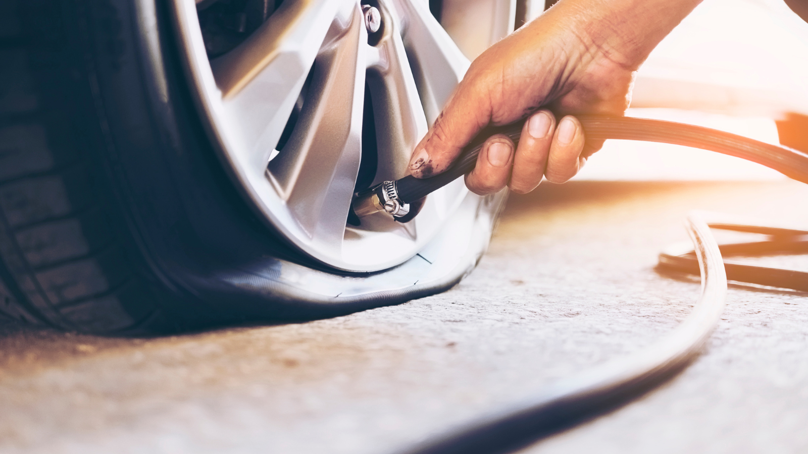 A person is pumping air into a flat tire.