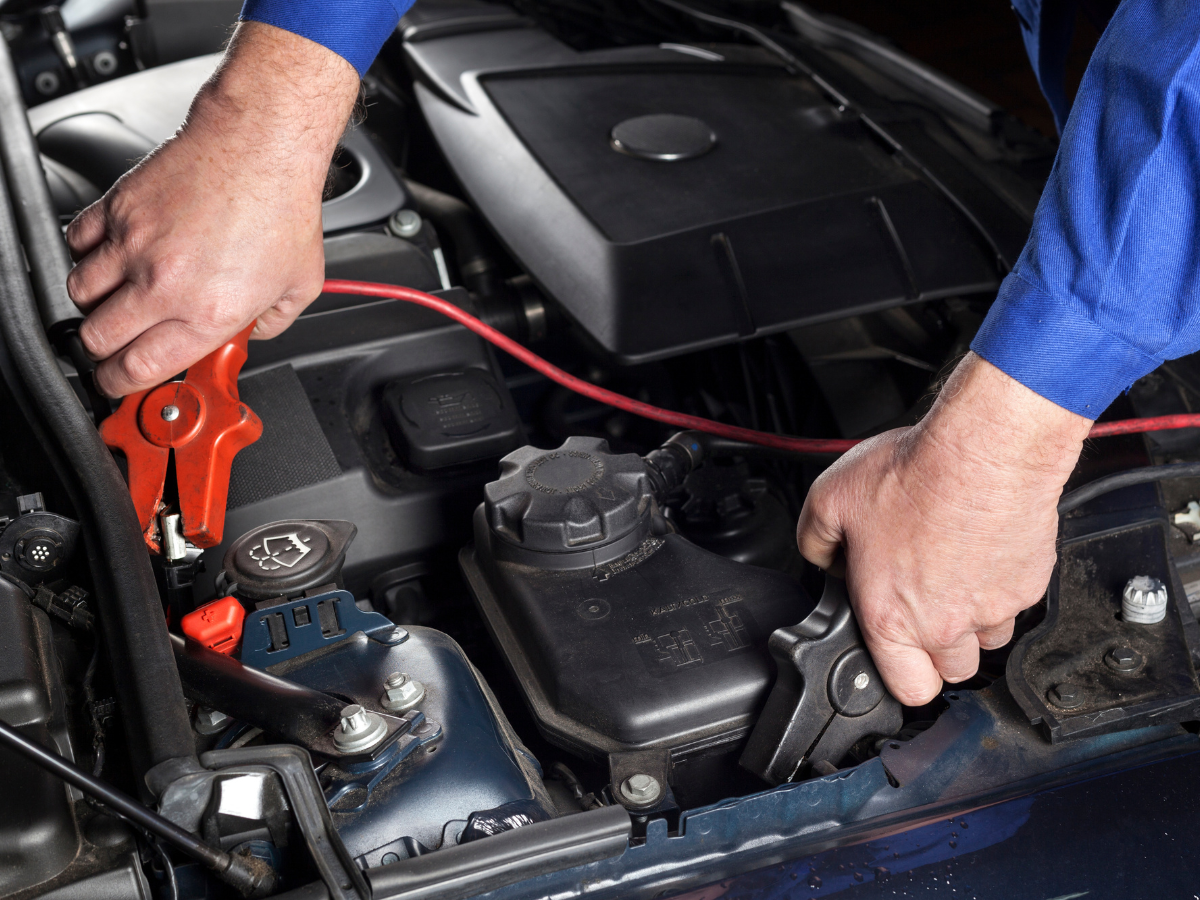 A man is working on the engine of a car