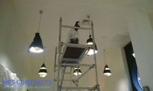 man fixing lights in a house