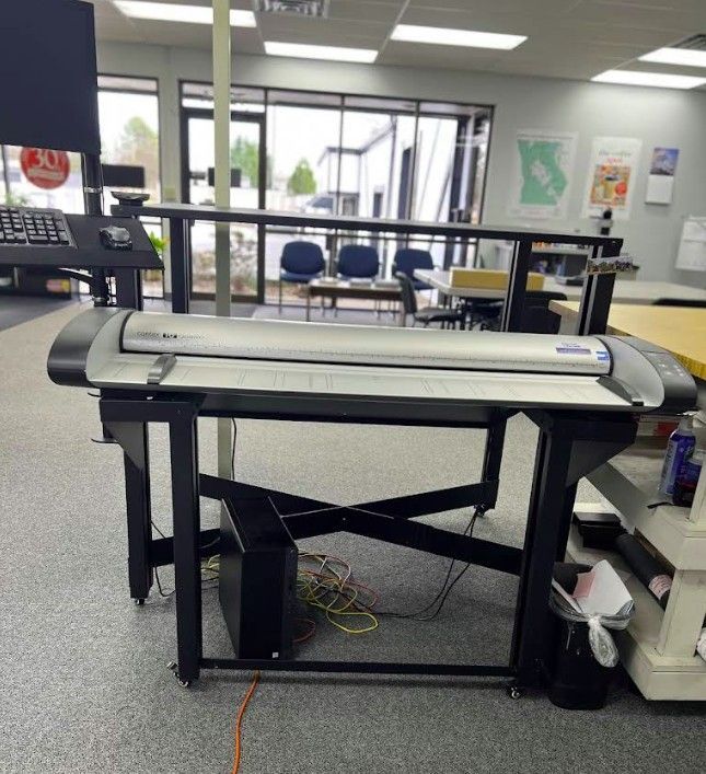 A large printer is sitting on a table in a room