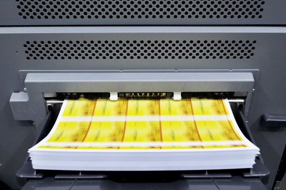 A stack of papers is being printed on a printer