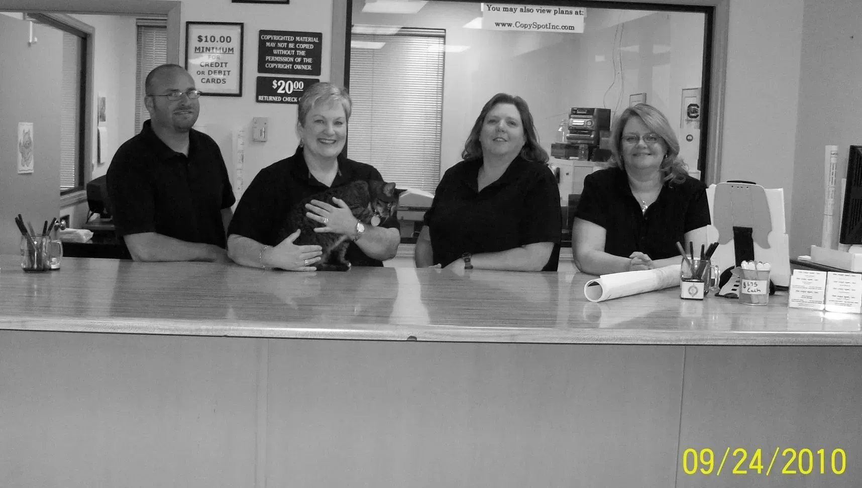 A black and white photo of a group of people sitting at a counter