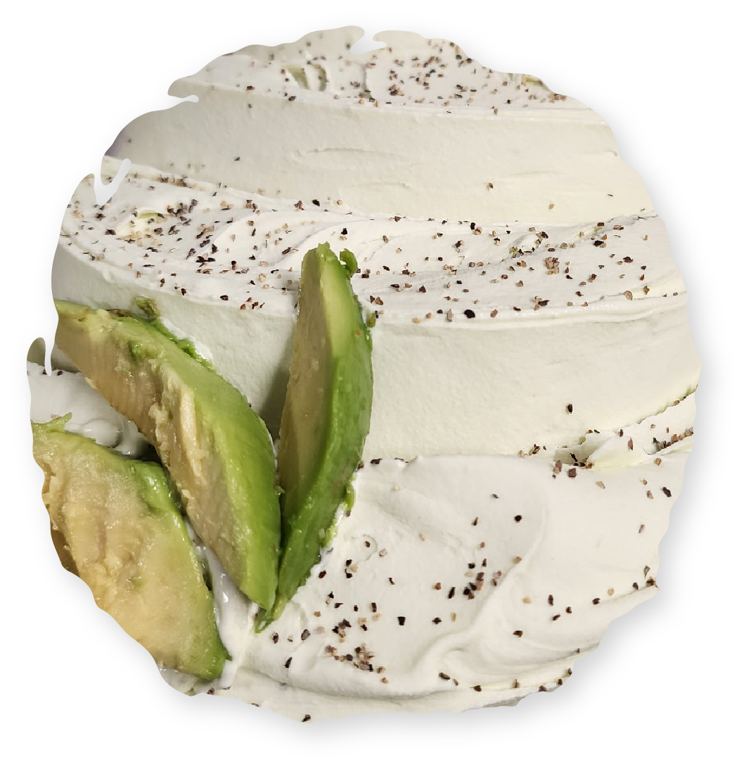 Whipped cream dessert with avocado slices and pepper sprinkles.
