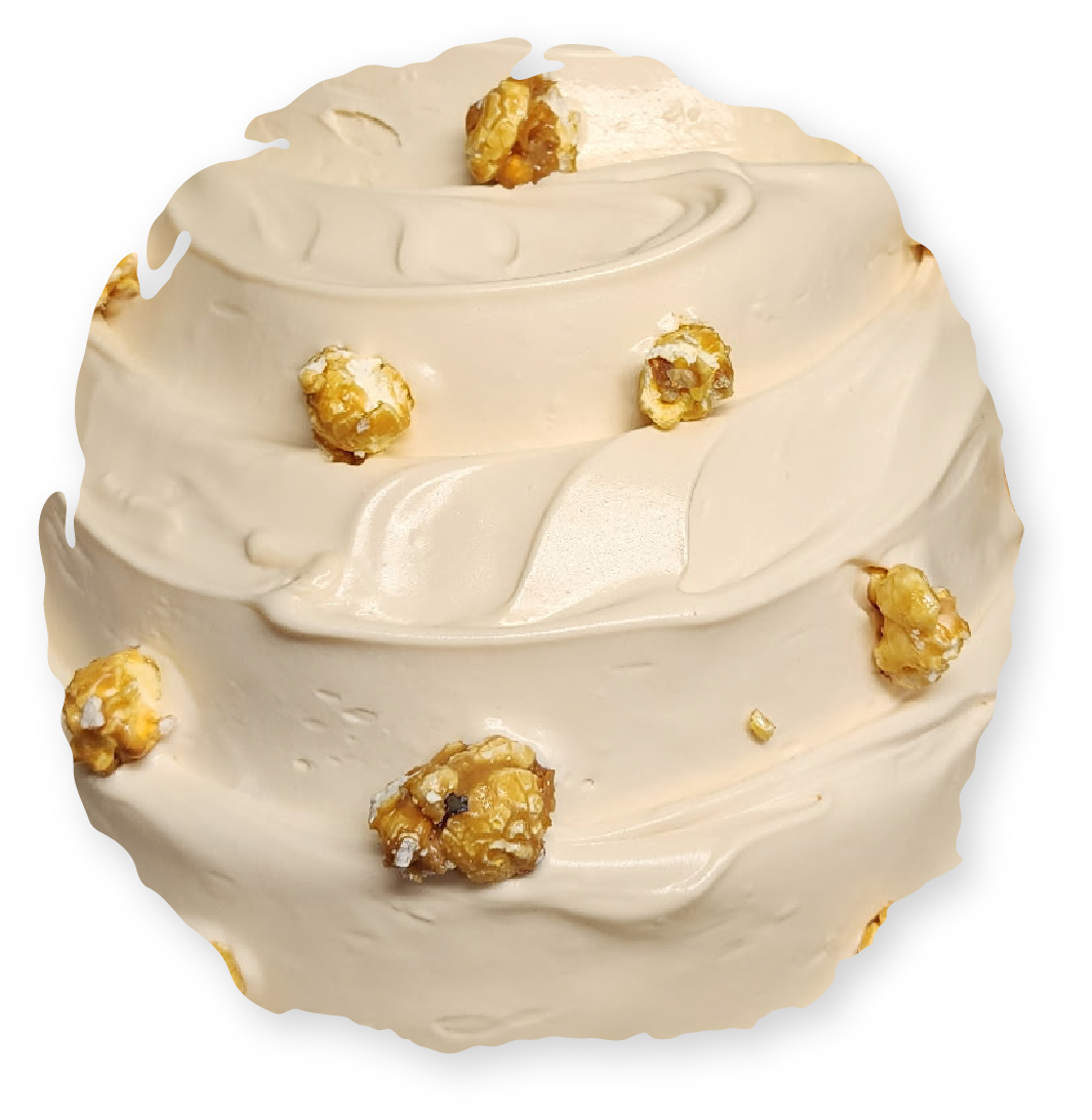 A scoop of caramel ice cream with pieces of caramel popcorn on top.