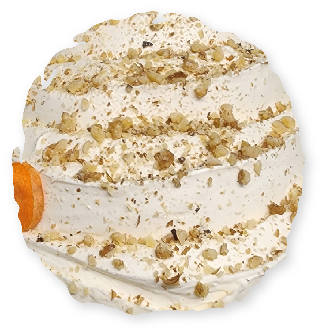 Carrot cupcake with white frosting, walnuts, and a carrot slice.