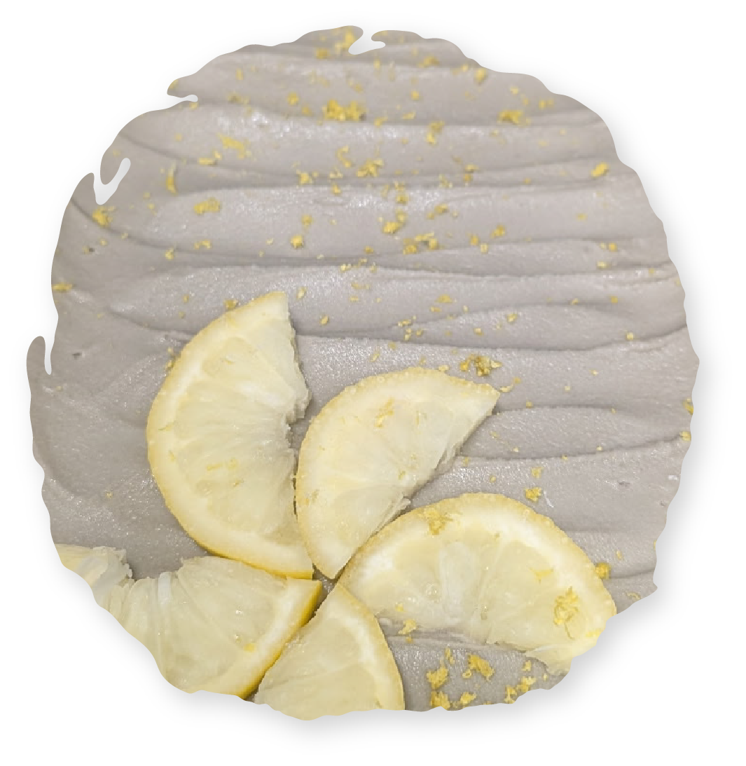 Grey dessert topped with lemon slices and zest.