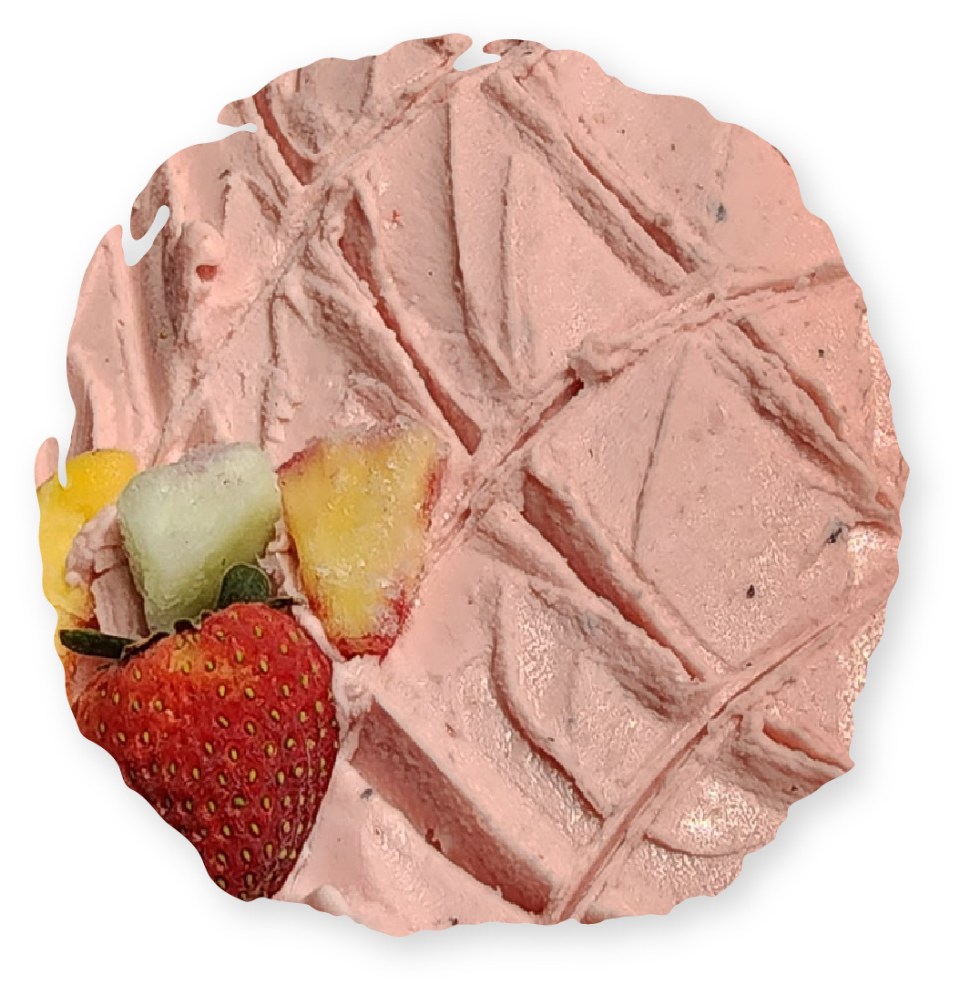 Waffle with pink frosting and fruit: strawberry, mango, and pear.