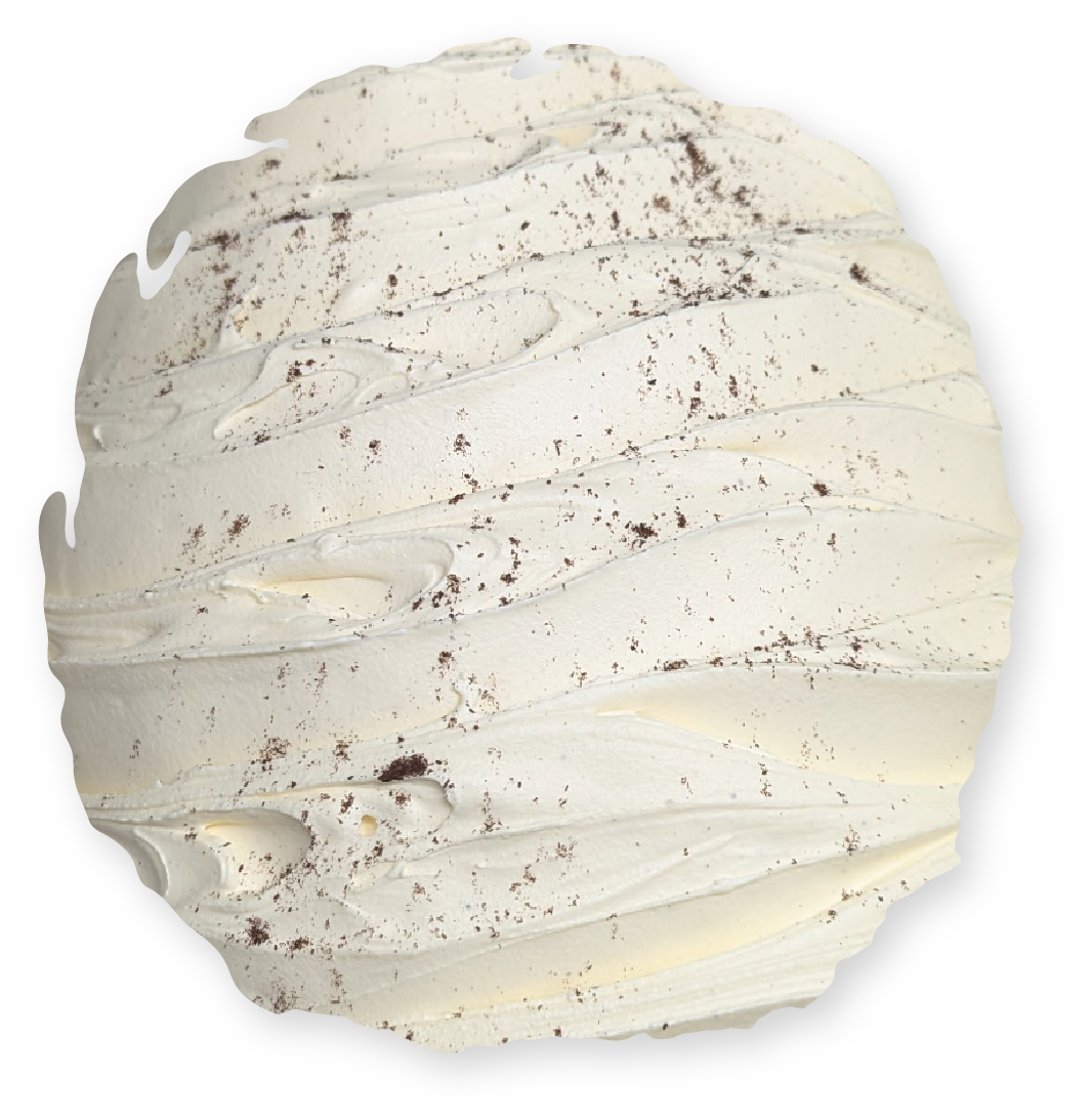 Close-up of white frosting, textured with a swirled pattern and tiny dark specks.