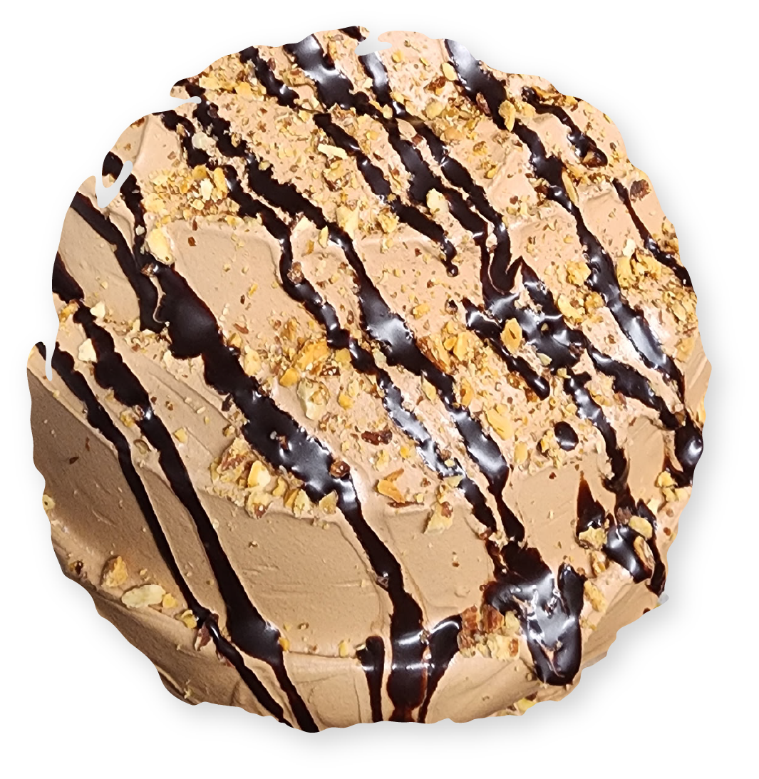 Chocolate cake with frosting, nuts, and chocolate drizzle.