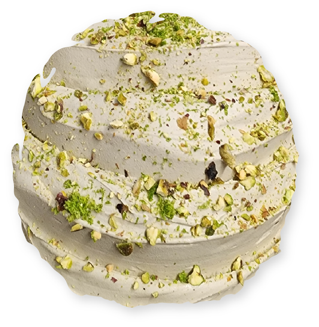 Scoop of pistachio gelato, pale green and brown, topped with chopped pistachios.