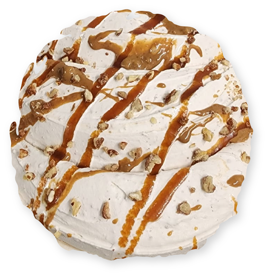 Pavlova dessert with caramel drizzle and chopped nuts.