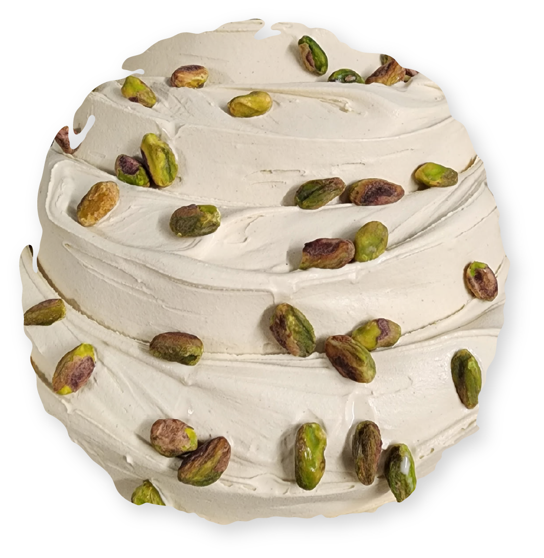 Swirled pistachio gelato, light brown with green pistachios on top.