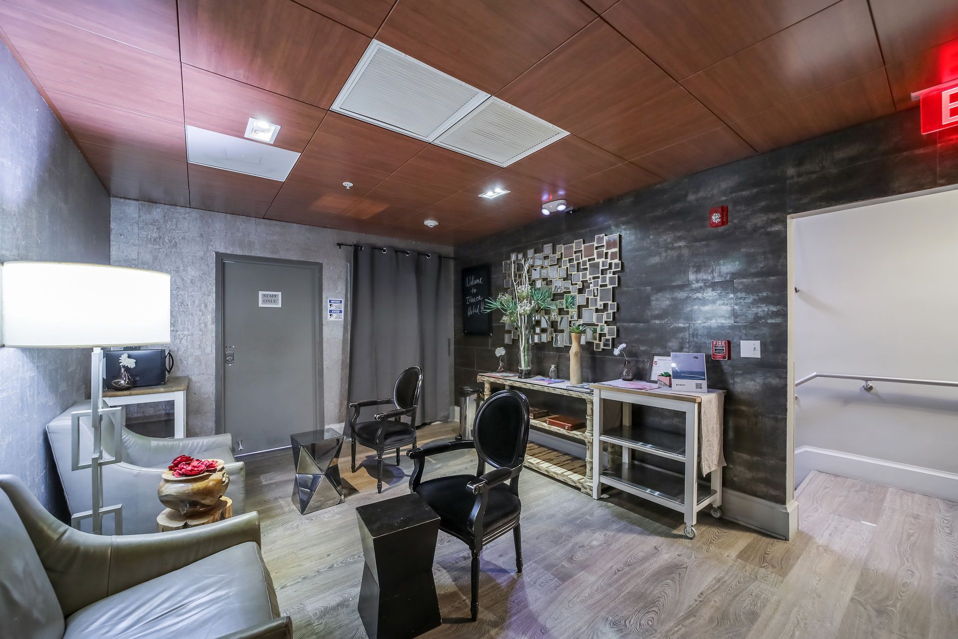 Waiting room with seating, decorative wall, and shelves.
